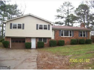 Split level home featuring brick and vinyl siding, a garage, and manicured shrubs at 401 Mt. Tabor Church Rd., Dallas, GA 30157