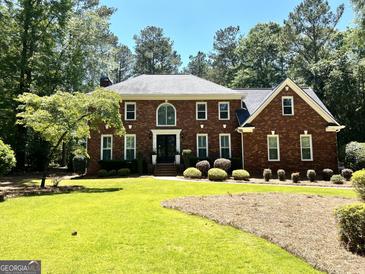 Traditional brick home showcasing a well-manicured lawn and lush landscaping for enhanced curb appeal at 111 Biltmore Trce, Peachtree City, GA 30269