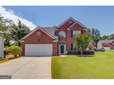 Charming two-story brick home with manicured lawn and attached two-car garage offers great curb appeal at 2990 Haynes Club Cir, Grayson, GA 30017