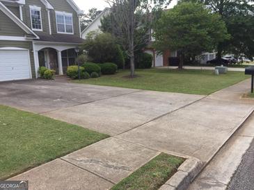 Charming two-story home featuring a spacious driveway, well-maintained lawn, and mature trees at 3639 Cape Ln, Conyers, GA 30013