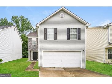 Charming two-story home with gray siding, black shutters, and a two-car garage at 1577 Keystone Dr, Conley, GA 30288