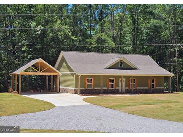 Charming one-story home boasts a spacious driveway and well-maintained lawn against a backdrop of lush trees at 518 Paynes Lake Rd, Carrollton, GA 30116
