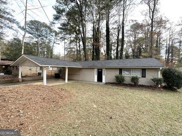 Charming single-story home with a covered carport and well-maintained front yard at 310 Flagstone Sw Dr, Atlanta, GA 30331