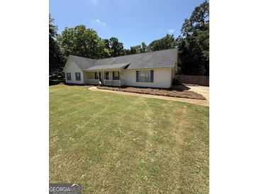 Charming single-story home with a well-manicured lawn, inviting porch, and classic blue shutters at 3005 Ryan Rd, Locust Grove, GA 30248