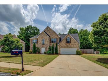 Lovely two-story brick home with mature trees, a well-manicured lawn, and a two car garage at 823 Hennepin Ter, Mcdonough, GA 30253