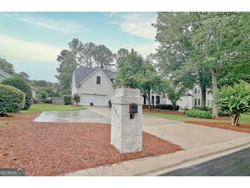 Charming two-story home with a manicured lawn and a driveway leading to an attached garage at 207 Tiverton Trl, Peachtree City, GA 30269