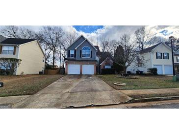 Charming two-story home features a two-car garage, lovely landscaping, and welcoming curb appeal at 1230 Chris Lake Dr, Lawrenceville, GA 30046