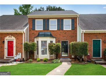 Charming brick townhouse with a well-manicured lawn and lovely front entrance at 1368 Poplar Se Pointe, Smyrna, GA 30082