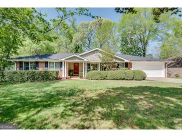 Charming single-story brick home with a well-manicured front yard and a vibrant red front door at 1448 Diamond Head Cir, Decatur, GA 30033