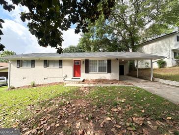 Charming single-story white brick home with a bright red front door and a covered carport at 3730 Stephanie Sw Dr, Atlanta, GA 30331