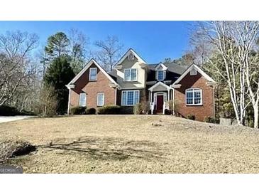 Charming brick home with a well-manicured lawn and a classic architectural design, under a clear blue sky at 1920 Lee Patrick Dr, Dacula, GA 30019