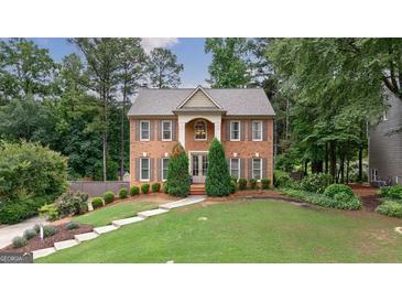 Charming brick two-story home with a manicured lawn and beautiful landscaping at 405 Woodbrook Way, Lawrenceville, GA 30043