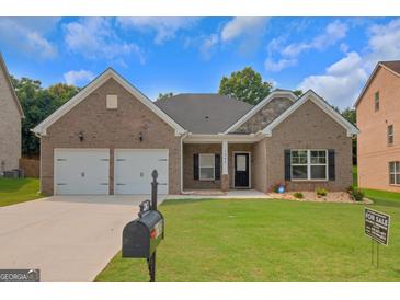 Charming brick home with a well-manicured lawn, two-car garage, and inviting front porch at 1243 Polk Xing, Mcdonough, GA 30252