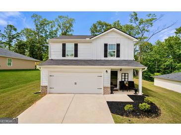 Charming two-story home boasts a white exterior, a well-manicured lawn, and inviting curb appeal at 340 Indian Lake Trl, Villa Rica, GA 30180