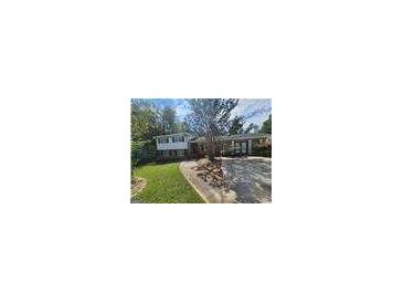Charming two-story home with a lush front yard, mature trees and a welcoming driveway at 3140 Kipling Dr, Powder Springs, GA 30127