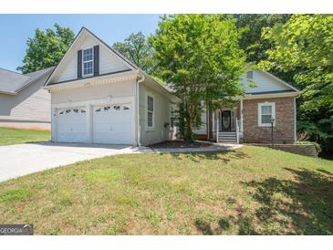 Charming home featuring a two-car garage, stone accents, and well-maintained front yard at 832 Windy Mill Ct, Temple, GA 30179