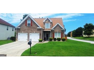 Charming two-story brick home featuring a well-manicured lawn, two-car garage, and classic architectural details at 7314 Basalt Dr, Union City, GA 30291