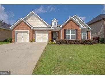 Charming brick home with a well-manicured lawn, two-car garage, and welcoming entrance at 395 Sylvan Loop, Fayetteville, GA 30214