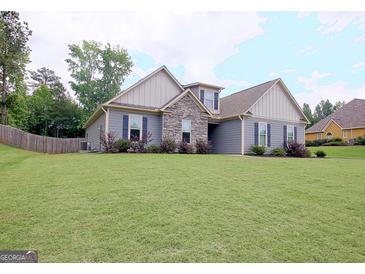 Charming one-story home boasts stone accents and a well-manicured lawn at 234 Thyme Leaf Way, Locust Grove, GA 30248