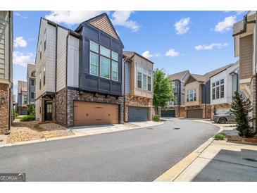 View of modern townhomes featuring unique architectural designs and attached garages at 1058 Kirkland Cir, Smyrna, GA 30080