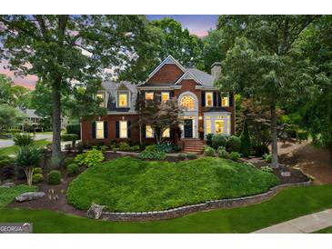 Stately brick home featuring manicured landscaping, shuttered windows, and a welcoming front porch at 750 Highview Ct, Woodstock, GA 30189