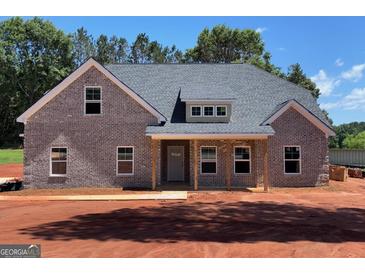 New construction featuring a gray brick exterior, covered front porch and professionally landscaped yard at 1705 Lake Dow Rd, Mcdonough, GA 30252