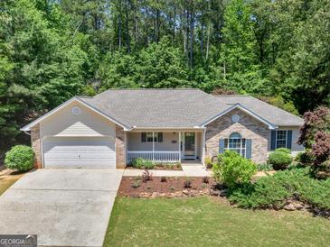 Charming single-story home with a well-manicured lawn and attached two car garage at 264 Keller Dr, Mcdonough, GA 30252