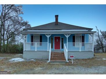 Charming blue single-story home featuring a brick stairs, red front door, and white porch at 1730 Spring Ne St, Conyers, GA 30012