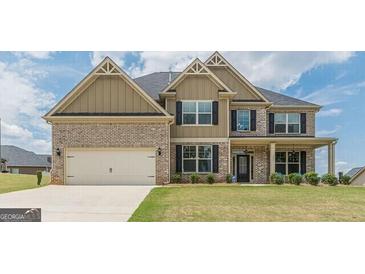 Two-story brick home with an attached two-car garage and a well-maintained lawn at 171 Osier Dr, Mcdonough, GA 30252