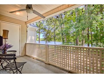 Charming patio with ceiling fan, string lights, and a beautiful lake view at 606 Ridgelake Dr, Peachtree City, GA 30269