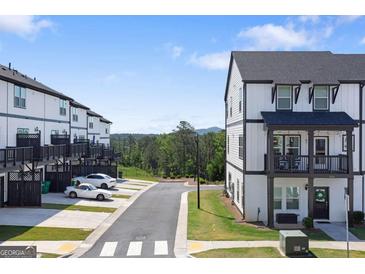 View of the new construction townhome exteriors, featuring a road and parking space at 823 Mackay Crk, Woodstock, GA 30188