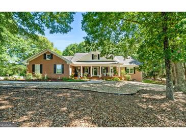 Charming brick home with a welcoming front porch and lush landscaping at 401 Riverwalk, Mcdonough, GA 30252