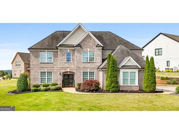 Stunning brick home with a meticulously manicured lawn and lush landscaping, exudes curb appeal and timeless elegance at 1516 Winward Dr, Locust Grove, GA 30248