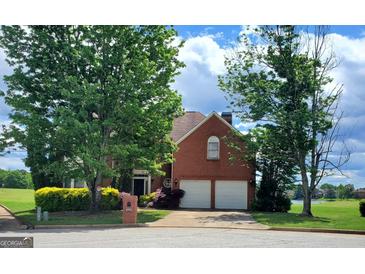 Charming brick home with a two-car garage, mature trees, and a well-maintained lawn at 690 Gateway Ct, Stone Mountain, GA 30087