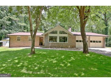 Beautiful brick home with large picture windows and a well-manicured lawn at 152 Dana Dr, Fayetteville, GA 30215