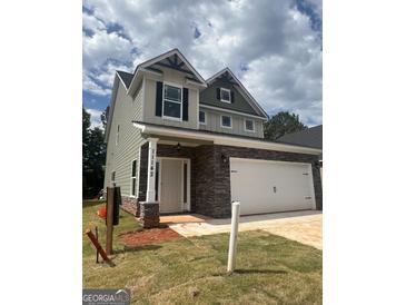 Charming two-story home featuring stone accents, a two-car garage, and a well-maintained front yard, creating instant curb appeal at 11142 Cornerstone Way, Hampton, GA 30228