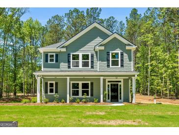 Charming two-story home showcasing a covered porch and manicured lawn at 1555 South Bethany Rd, Locust Grove, GA 30248