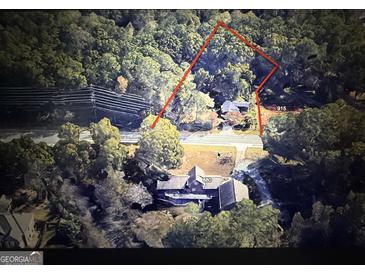 Expansive aerial view of the wooded lot and the property featuring the boundaries outlined in red at 905 John Ward Sw Rd, Marietta, GA 30064