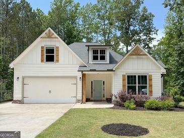 Charming single-story home featuring white siding, craftsman-style details, a two-car garage, and a well-manicured front yard at 3455 Henderson Dr, Cumming, GA 30041