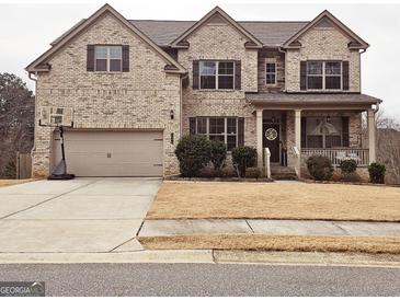 Charming two-story brick home with well-maintained landscaping and an attached two-car garage at 1690 Geranium Ln, Cumming, GA 30040