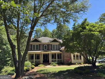Charming brick two-story home with a welcoming front porch and beautifully landscaped front yard at 245 River Laurel Way, Woodstock, GA 30188
