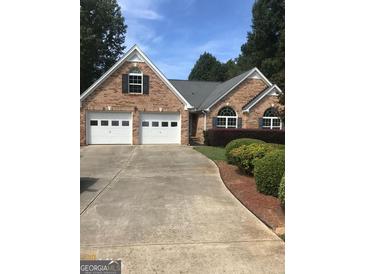 Charming brick home featuring a two-car garage and well-maintained landscaping at 436 Abbey Pl, Villa Rica, GA 30180