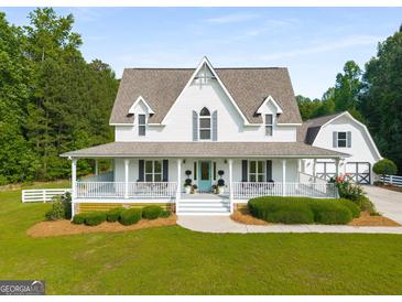 Charming two-story home with a welcoming porch and well-manicured lawn at 692 Brooks Woolsey Rd, Brooks, GA 30205
