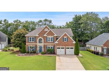 Charming brick two-story home with a well-manicured lawn and lovely landscaping at 960 Pebblestone Ct, Alpharetta, GA 30009