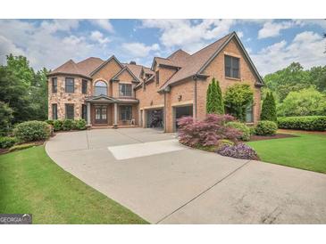 Beautiful two-story brick home featuring a large driveway and well-maintained landscaping at 4818 Moon Hollow Ct, Buford, GA 30519