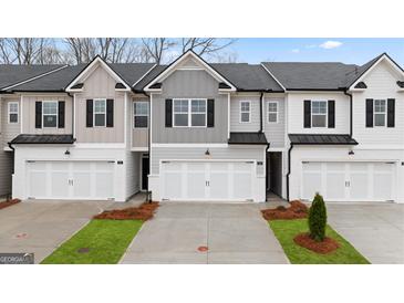Charming townhome showcasing a modern exterior with attached garages and well-manicured landscaping at 314 Sound Cir, Stockbridge, GA 30281
