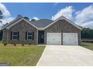 Charming single-story home featuring a brick facade, two-car garage, and well-manicured lawn at 1676 Fuma Leaf Way # 305, Mcdonough, GA 30253