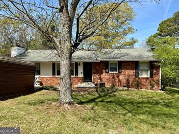 Charming single-story brick home with a well-maintained front yard and mature shade trees at 107 Woodhaven Dr, Stockbridge, GA 30281