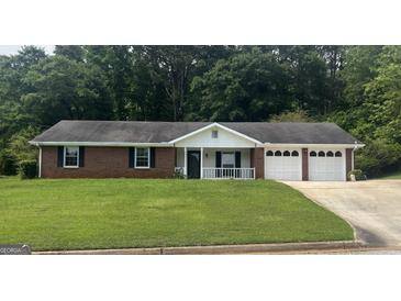 Charming brick home with attached two car garage, black shutters, and white trim at 3857 Pointers Sw Way, Conyers, GA 30094