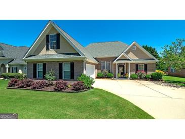 Charming brick home with manicured lawn, lush landscaping, and inviting entrance at 127 Laurel Springs Dr, Mcdonough, GA 30253
